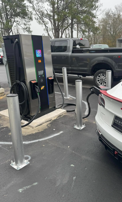 Pedestal EV fast charger installed outdoors with bollards protecting the unit